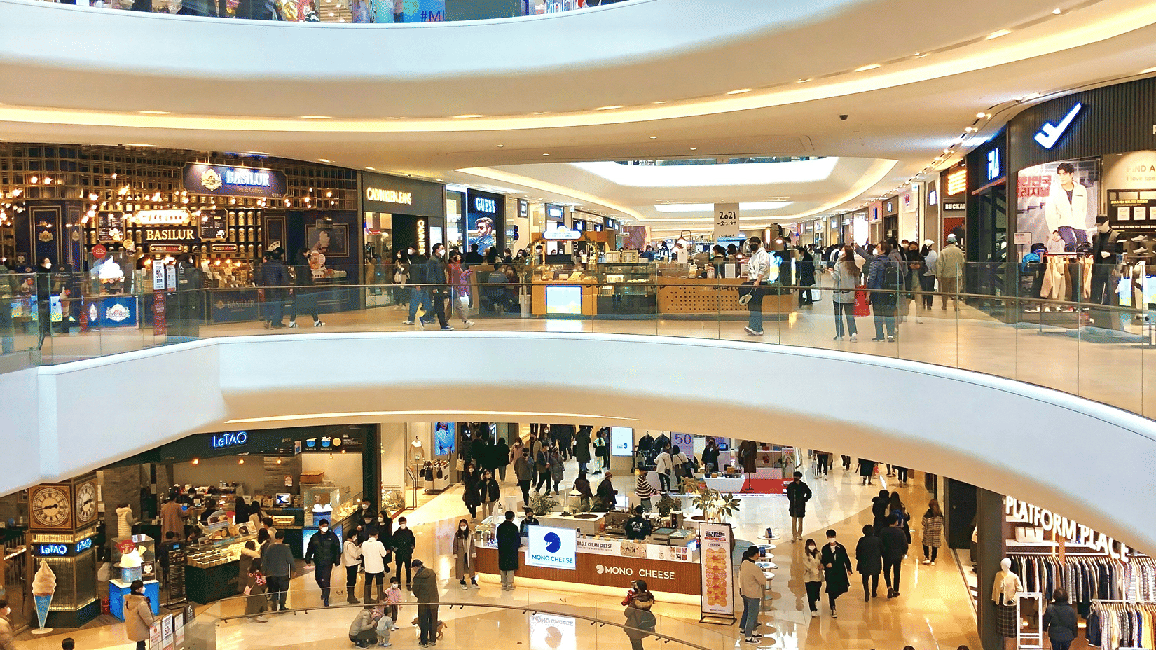 Interiors of a mall featuring multiple storeys and people walking around