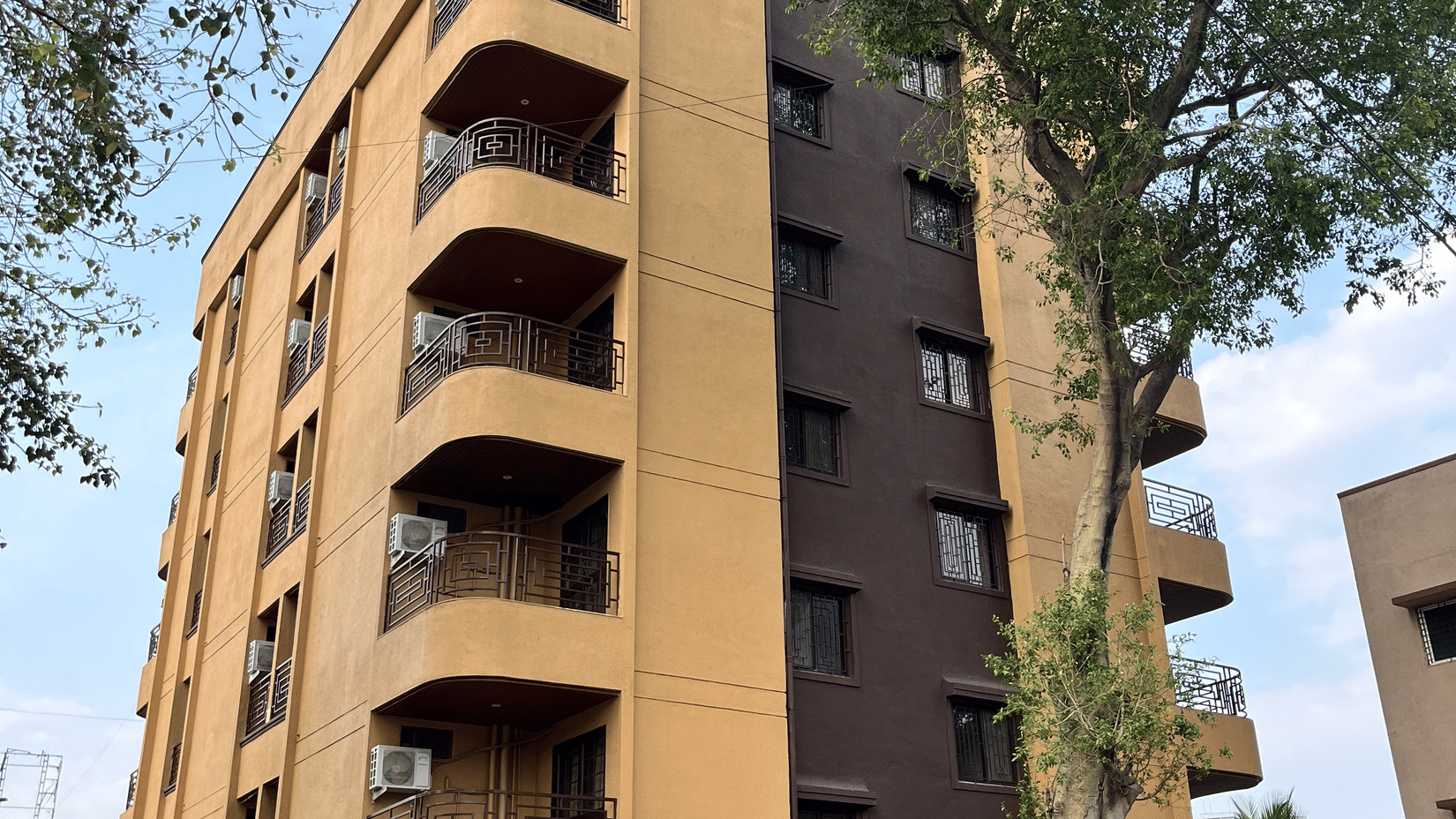 Facade of VITS Select Kharadi, Pune, our hotel near Pune Airport, with curved balconies stands beside tall trees