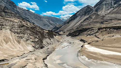 A top view of a valley with a water body nestled along its edge.