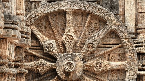 Sun Temple's carved stone wheel, highlighting intricate spokes, floral motifs, and weathered craftsmanship against ancient temple walls