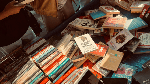 A pile of various books are stacked haphazardly in a crate | Chennai Book Fair Location