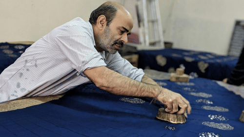 An image of a person doing block print on a cloth