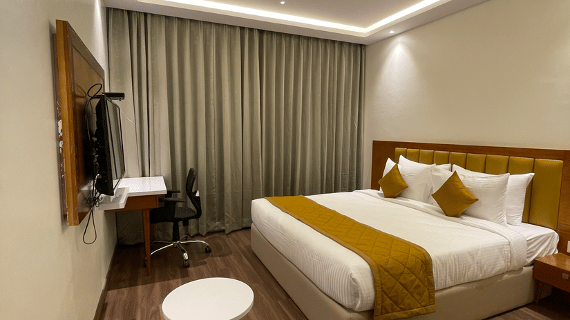 Bedroom with king size bed with white covers-  Quality Inn Rockwell Grand