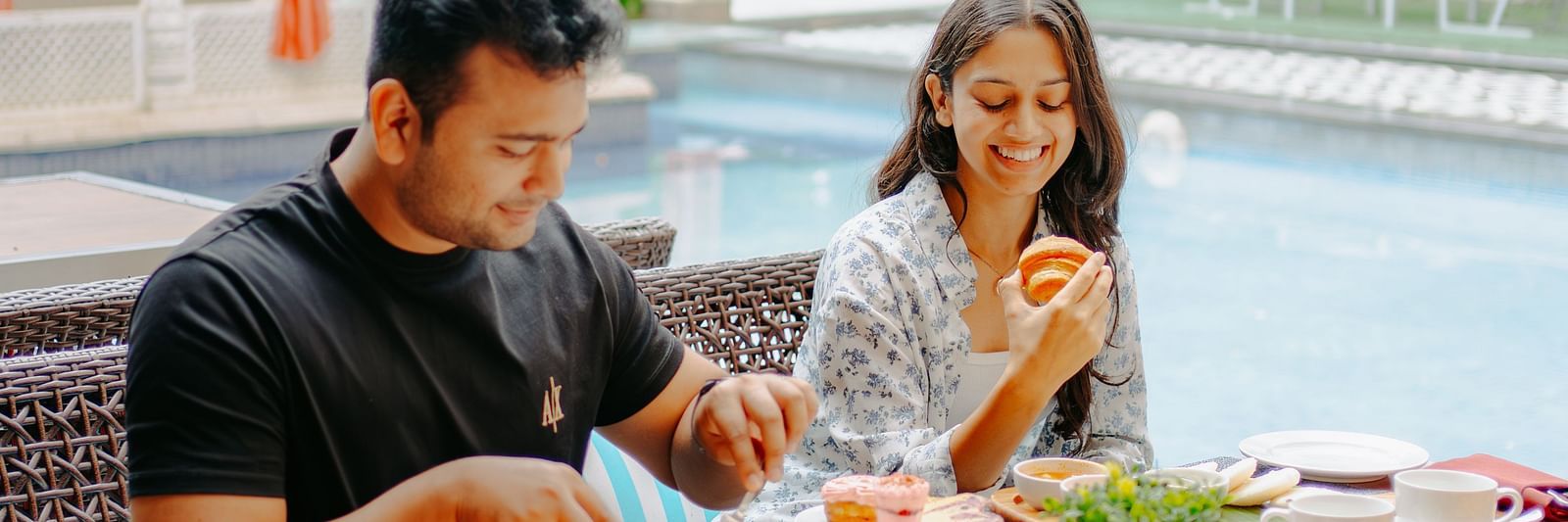A couple enjoying their breakfast beside the pool area at Crescent Spa & Resort, Indore