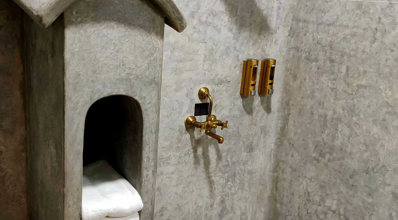 Yellowfin-washroom in grey theme, with a unique post box shaped place holder for keeping towels, a copper  bucket and all the furnishings in copper.