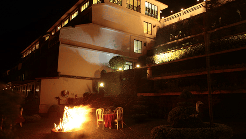 Abad Copper Castle exterior at night, lit with warm lights.