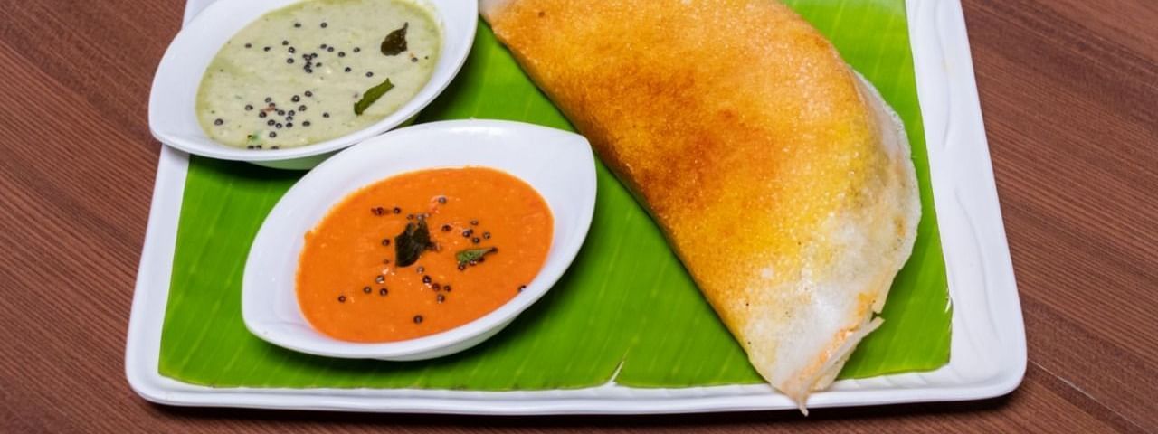 A dosa on a plate with two different types of chutney from Mulbagal Dosa at Hotel Pai Viceroy Jayanagar