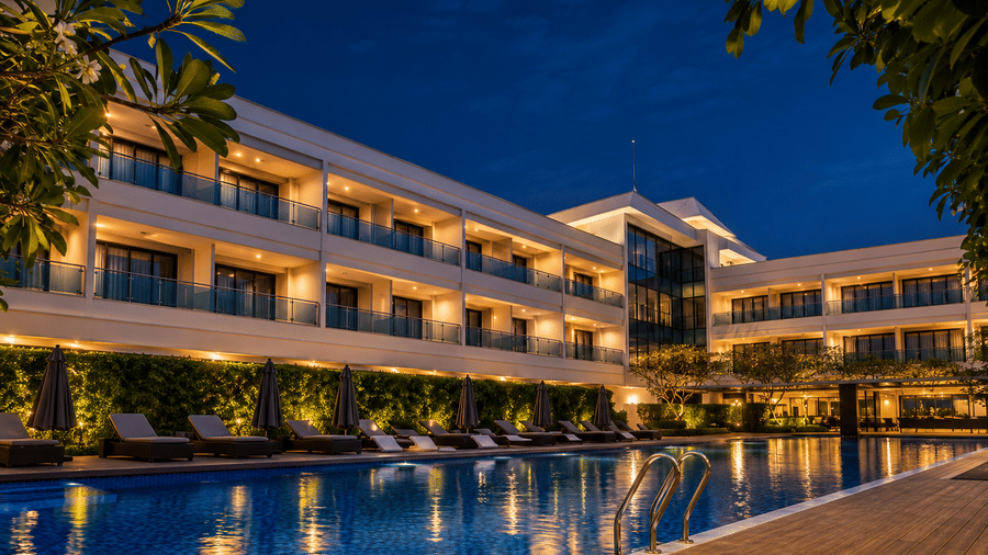Illuminated outdoor swimming pool against the night exterior of Kiranshree Grand Hotel.