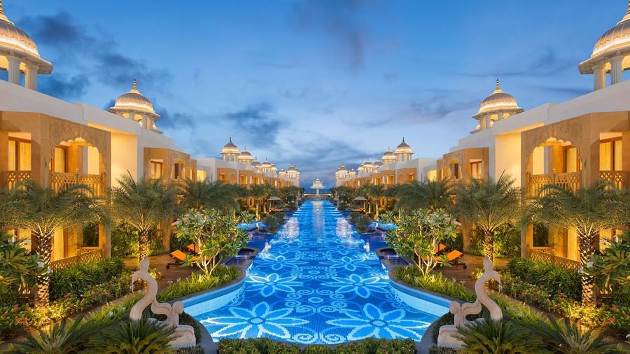 A view featuring a pool lit in blue colour with buildings of rajasthani architecture on either sides - Kaldan Samudhra Palace