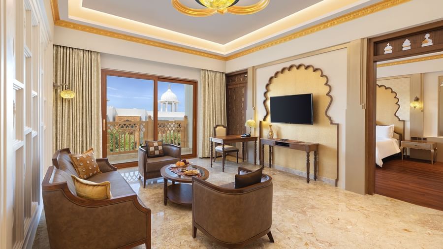 A seating area in our suite in Mahabalipuram with large windows, neutral tones, and cosy armchairs - Kaldan Samudhra