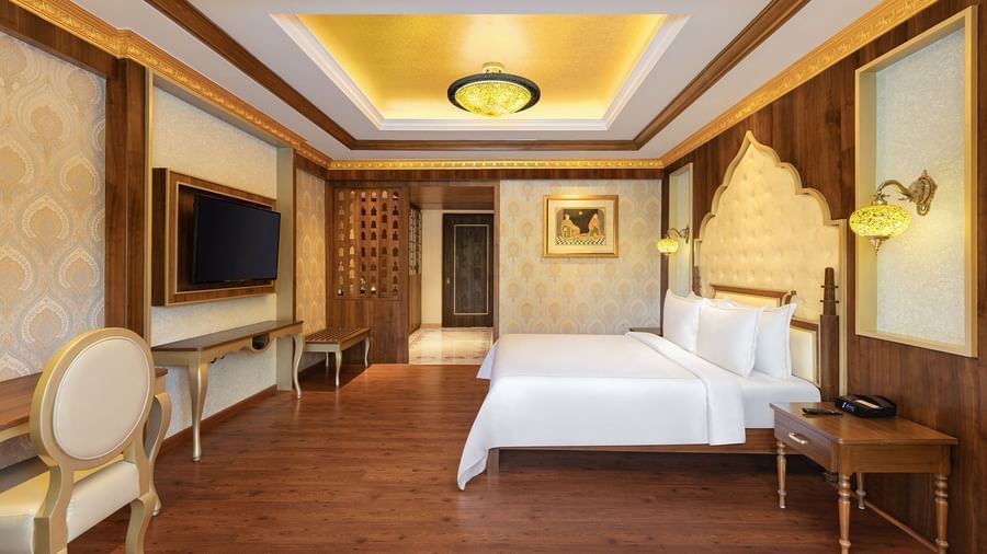A hotel room in Mahabalipuram with rich wooden flooring, a large bed, and comfortable seating arrangement – Kaldan Samudra, one of the top beach resorts in ECR