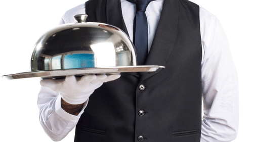 a man holding a cloche for in-room dining