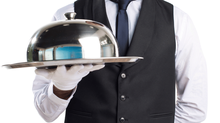 a man holding a cloche for in-room dining