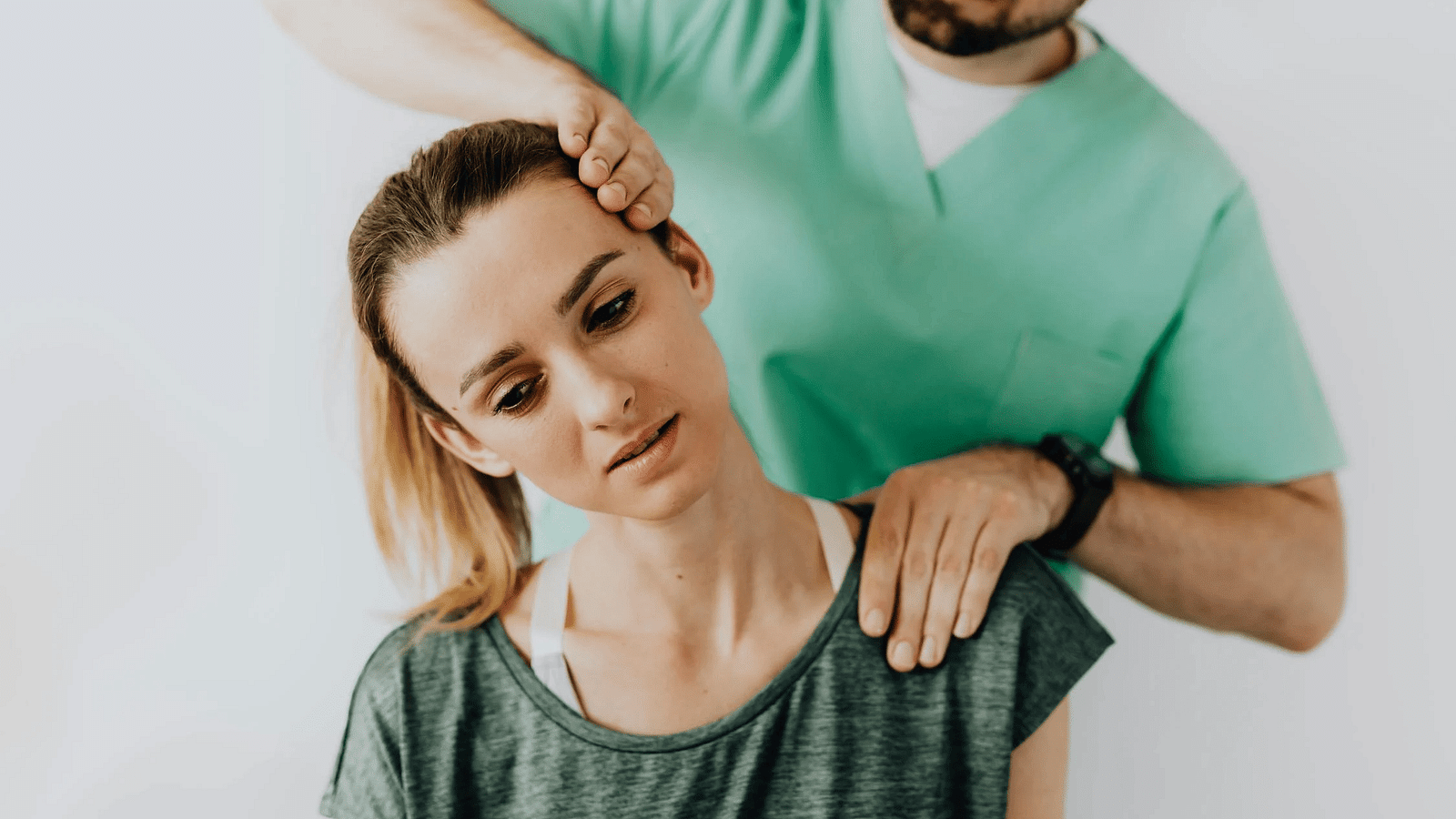 A massage therapist working on the neck of a woman.