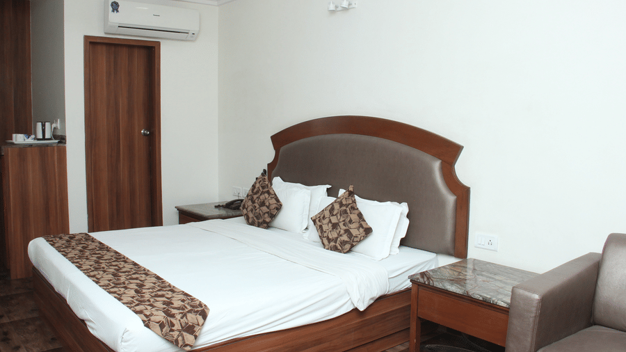 Hotel room with a double bed, wooden furniture, and air conditioning