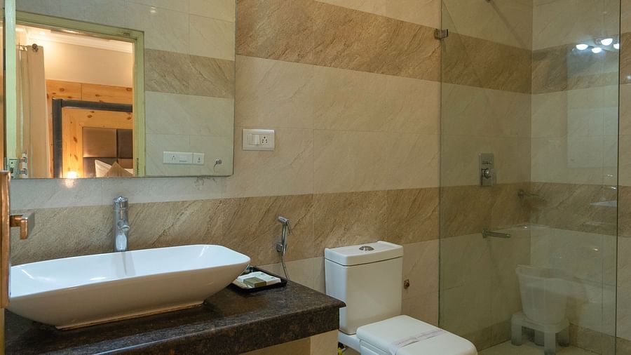 Modern bathroom with glass shower at The Tattwaa Corbett Spa & Resort.