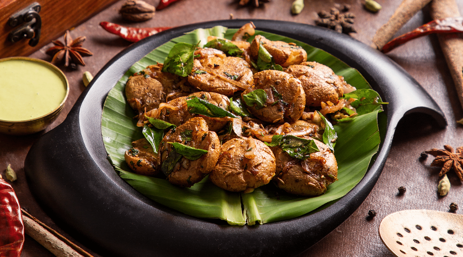 Exotic Indian spices and food served in a modern black dish. | Kamats India