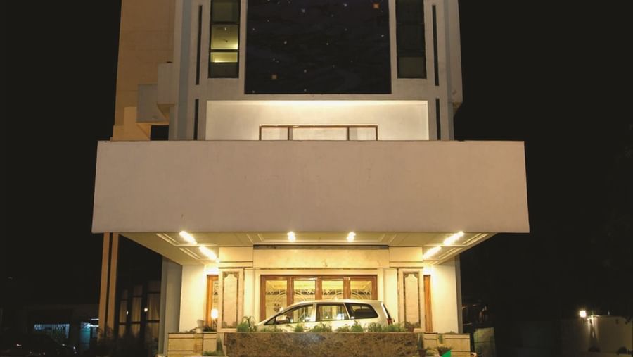 The facade view of a modern hotel building illuminated with lights in the ground floor  at night time.