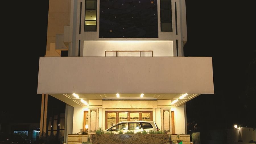 Facade of a night-time view of a modern hotel building illuminated with lights in the ground floor | Gemini Continental