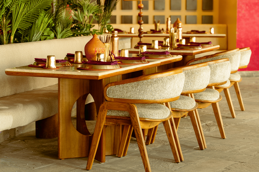 Interior view of Jamun restaurant featuring wooden tables, chairs, and warm ambient lighting - Symphony Resorts