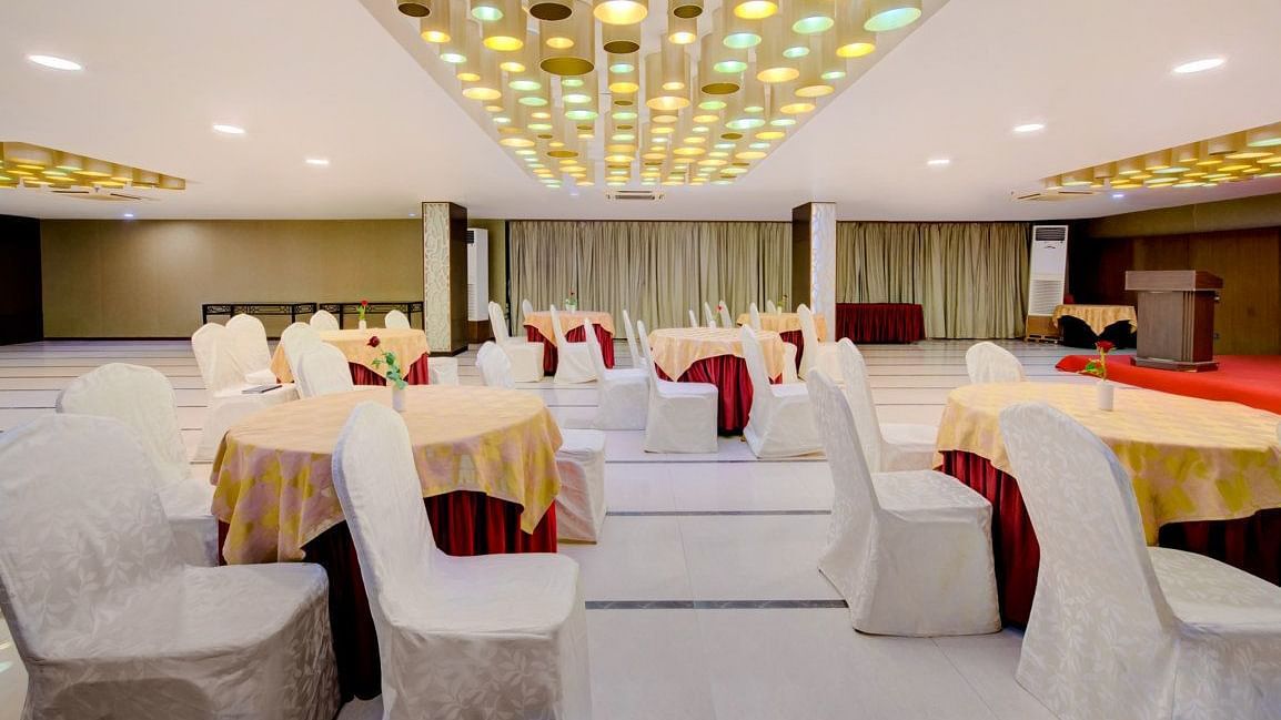 Elegant banquet setup with round tables and white chair covers at Voyage Milestone Hotel and Banquet Siliguri