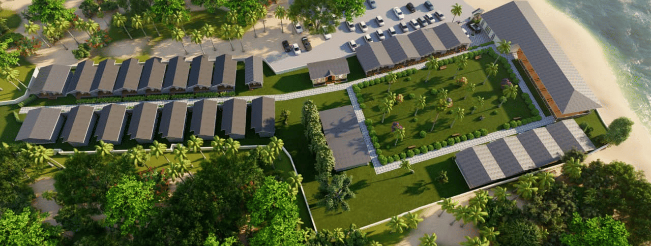 An aerial view of Trishvam Palolem Beach Resort, Goa, with units of houses nestled between the greenery by the shore.