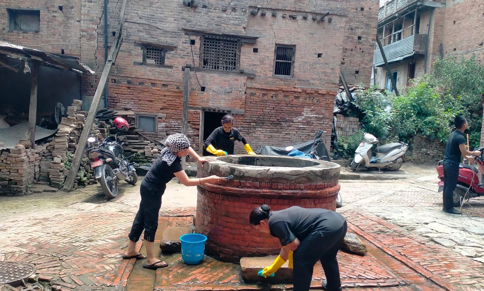 Two men seen cleaning a well