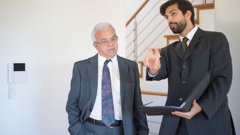 Two men having an interactive discussion where one of the man is holding a file