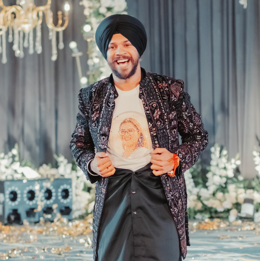 Groom Jaswinder in traditional attire showing bride Ritika’s photo on his shirt at Umaid Palace wedding.