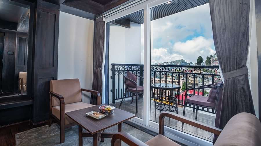 Image of the seating space of a room near the balcony featuring two sofas and a table.