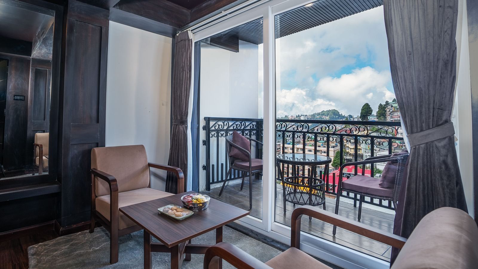 Image of the seating space of a room near the balcony featuring two sofas and a table.