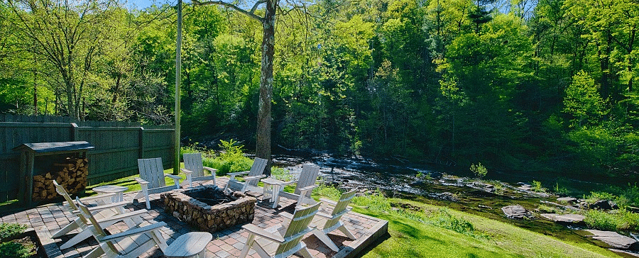 corner view of the outdoor seating area with a fire pit highlighting the mesmerizing views of the surrounding forests - Historic Tapoco Lodge