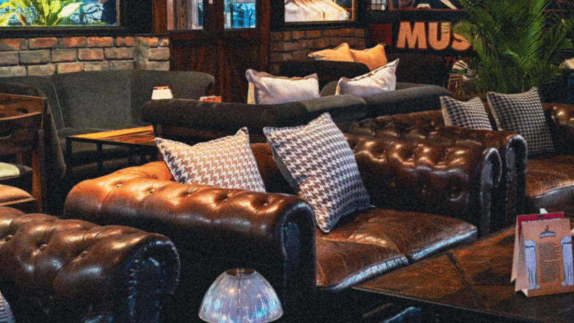 Leather seating and ambient lighting inside a stylish lounge bar with artwork, cosy seating areas, and a relaxed nightlife atmosphere