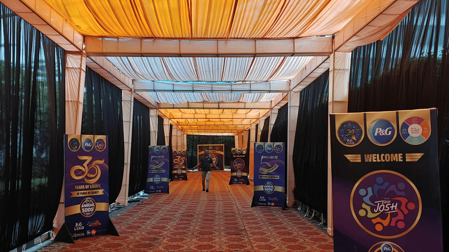A long indoor walkway with a patterned carpet, fabric-draped ceiling, and branded display panels along the sides.