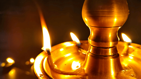 Traditional oil lamp being lit during a cultural or festive ritual