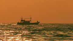 sunset view with a boat travelling in the ocean in chennai 