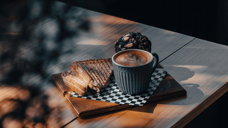A cup of coffee on a wooden table.