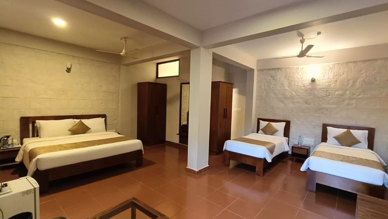 Elegant Deluxe Family Room at Woodstock Resorts, Coorg with twin beds, spacious layout, and warm, inviting interiors.