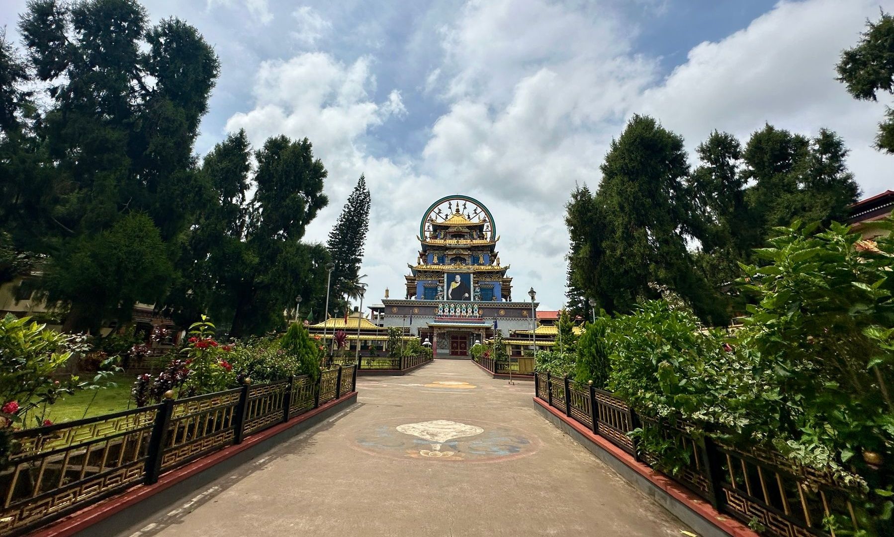 Namdroling Monastery with lush gardens and blue sky.