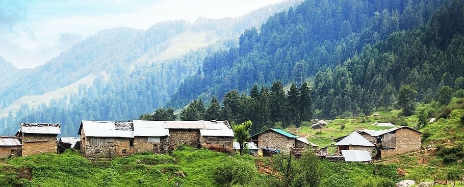 Lush green landscape with a mountain range in the background with a clear blue sky
