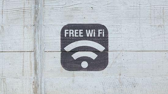 A stenciled sign of 'FREE Wi-Fi' on a textured concrete wall.