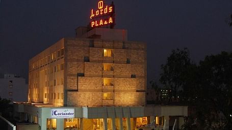 Facade of Lords Plaza Ankleshwar with illuminated lights, featuring its family restaurant and a bright sign displaying the hotel's name at night