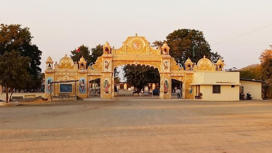 Grand ornamental entrance gate of Satadhar, adorned with intricate carvings amidst serene surroundings.