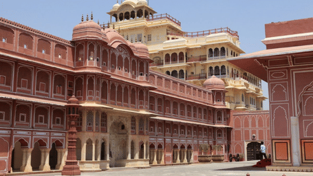 A multi-storey pink and white palace with multiple arches.