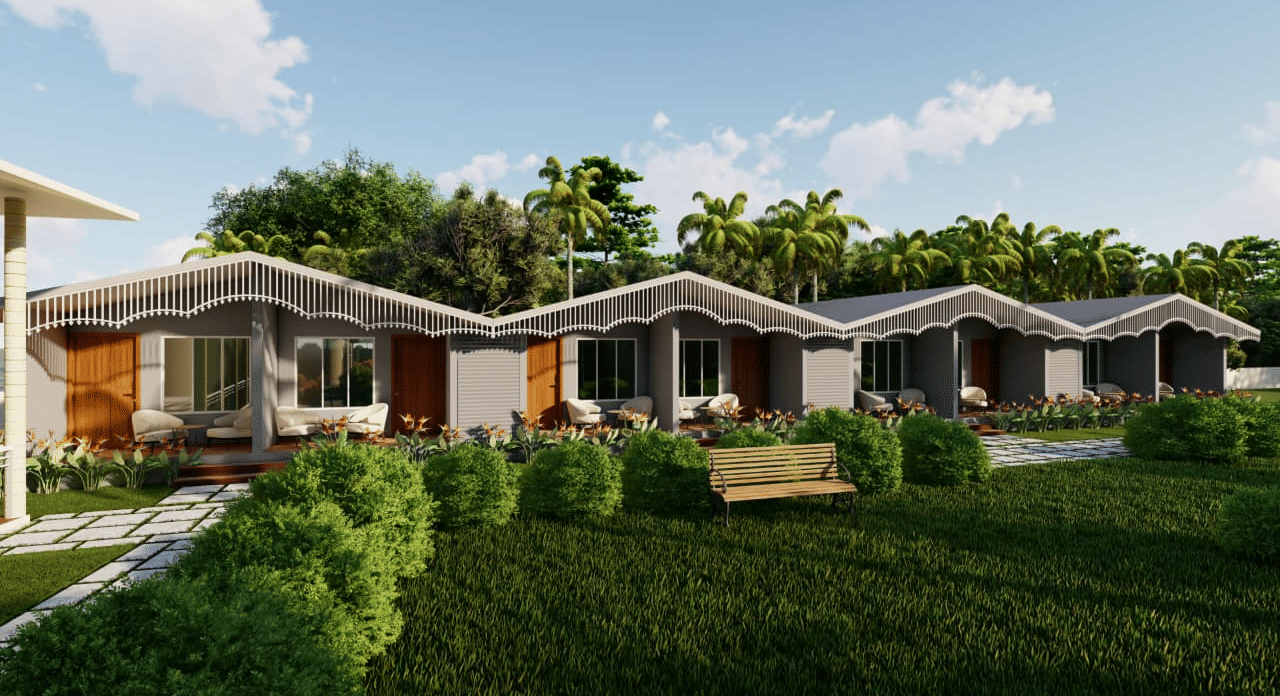 A row of small houses faces a lawn with a wooden swing set and several palm trees at the background at Trishvam Palolem Beach Resort, Goa.