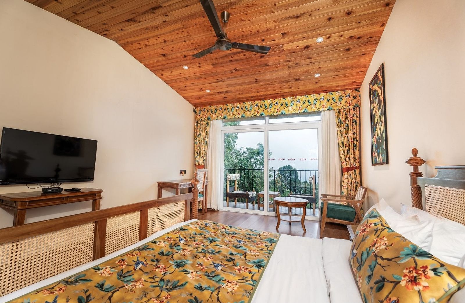 A room at Summit Barsana Resort & Spa, Kalimpong with a double bed, a television and a balcony