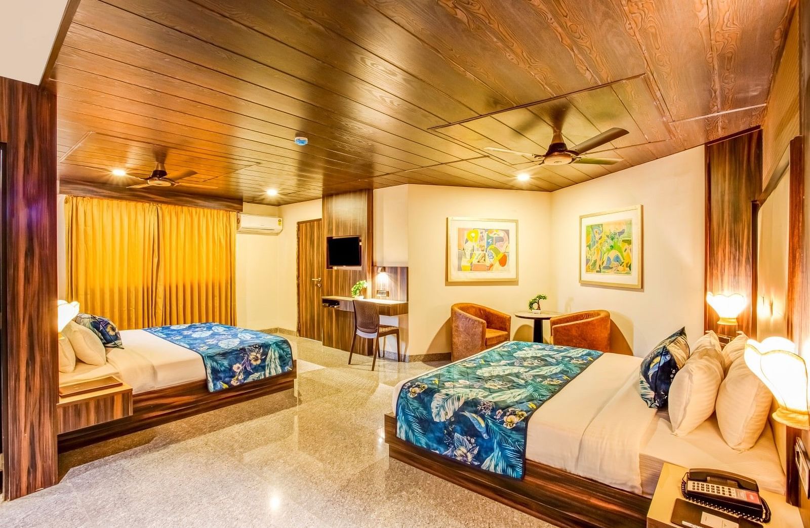  Family room with a private balcony featuring two beds, ceiling fans, and large framed photographs