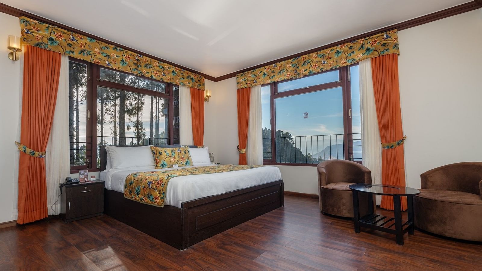 Image of a room with bed, sitting area and view of the mountains at Summit Sherpa Mountain Hotel & Spa, Kalimpong