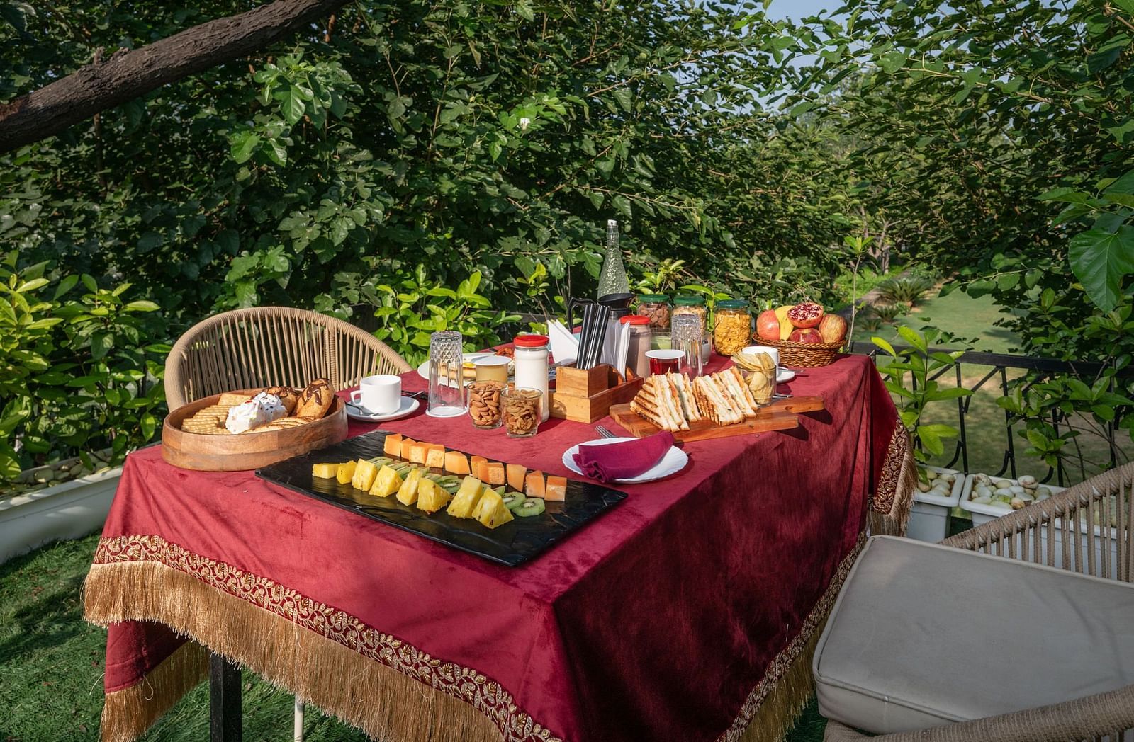 A table filled with food set in an outdoor space surrounded by lush plants at Valley by Grassfield.