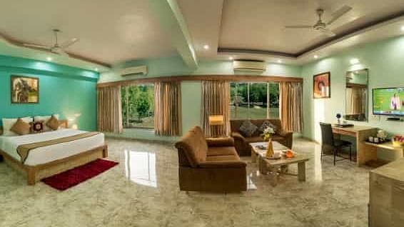A colourful room offering a double bed, a seating area with sofas, and a television - Lion Lords Inn Rajula